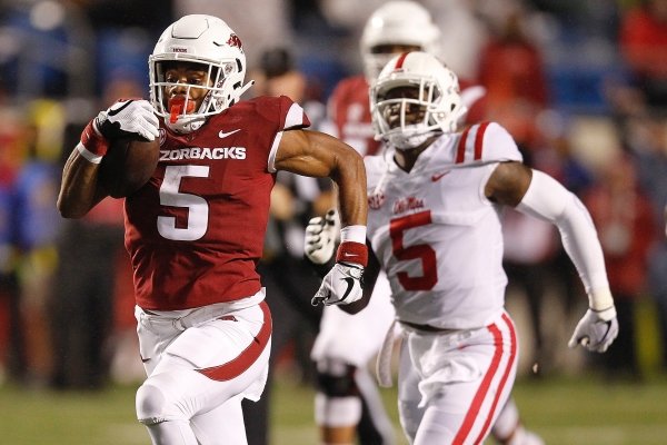 Arkansas running back Rakeem Boyd (left) races to the end zone for a 69-yard touchdown during the first quarter on Saturday, Oct. 13, 2018, at War Memorial Stadium in Little Rock.