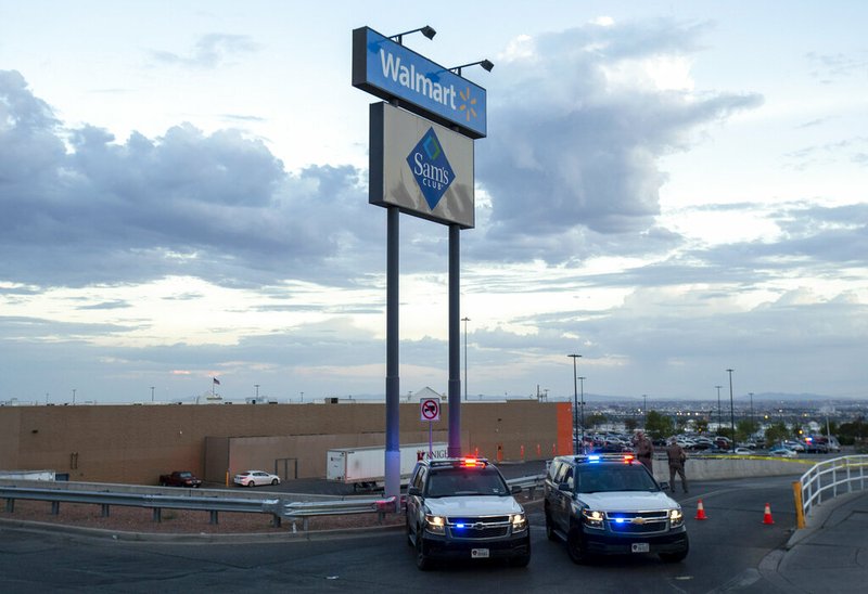 In this Aug. 3, 2019, photo texas state police cars block the access to the Walmart store in the aftermath of a mass shooting in El Paso, Texas. The Bentonville, Arkansas-based discounter says Tuesday, Sept. 3, that it will be discontinuing the sale of short-barrel and handgun ammunition. (AP Photo/Andres Leighton, File)