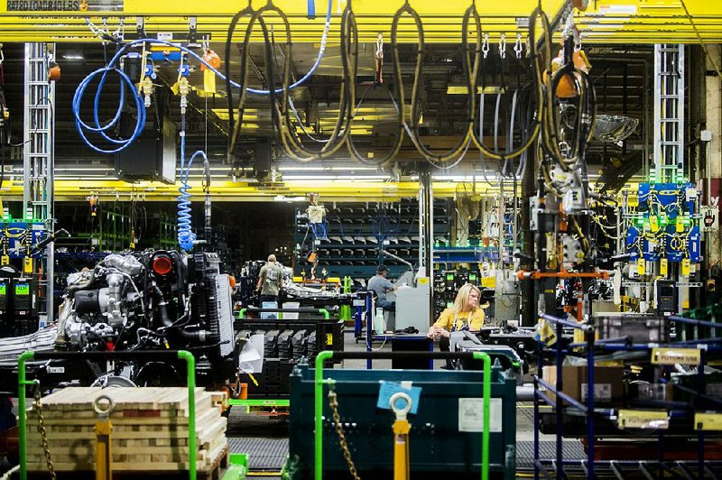General Motors employees work on the chassis line in June at GM’s assembly plant in Flint, Mich. A key U.S. factory gauge unexpectedly contracted in August for the first time in three years as slowing growth was reported by seven manufacturing industries, including transportation. 