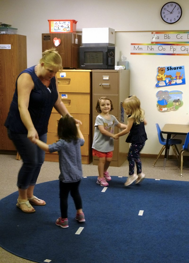 Lynn Atkins/The Weekly Vista Teacher Daphne Willaby dances with some of her "Caterpillar" class of 3-year-olds at the Bella Vista Preschool last week.