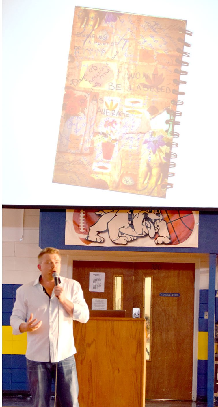Westside Eagle Observer/MIKE ECKELS Craig Scott, a survivor of 1999 Columbine massacre, shows to a crowd gathered at Peterson Gym in Decatur Aug. 29 the journal in which his sister, Rachel Joy, wrote every day. Rachel was the first person killed in the attack on Columbine High School in Littleton, Colo., which claimed the lives of 12 students, one teacher and both gunmen.