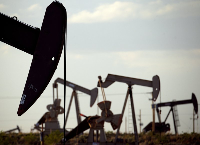In this April 24, 2015, file photo, pumpjacks work in a field near Lovington, N.M. State economists on Friday, Aug. 23, 2019, revised upward forecasts for state government income amid surging oil and natural gas production in New Mexico, giving lawmakers greater leeway as they begin crafting a general fund spending plan for the coming fiscal year.  (AP Photo/Charlie Riedel, File)