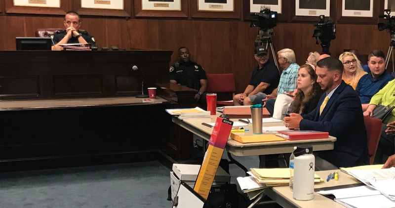 Capt. Heath Helton, left, testifies during a hearing for former officer Charles Starks' appeal of his firing. Starks is seated at the table on the right.