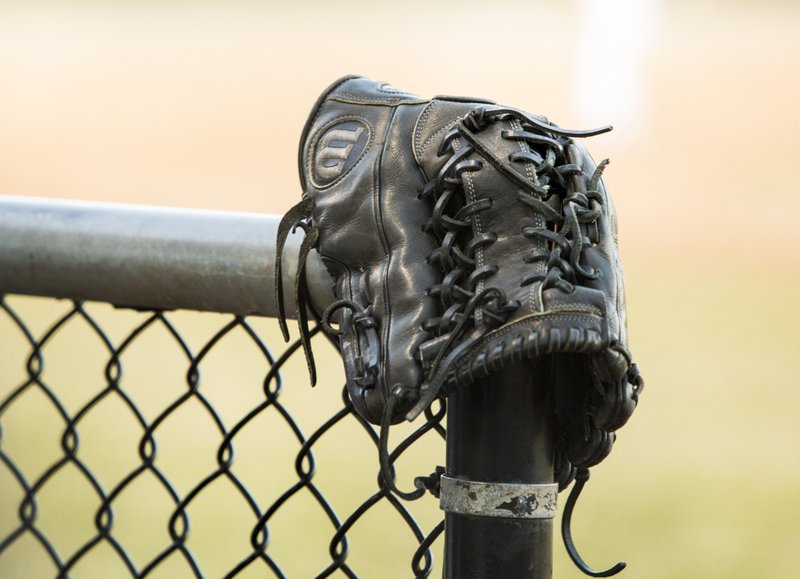 File photo -- A baseball glove rests on a fence.