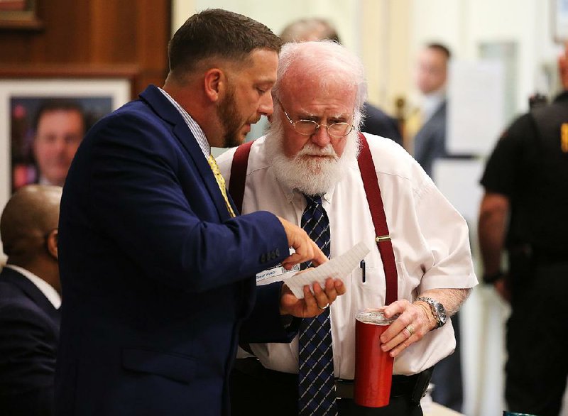 Former Little Rock police officer Charles Starks (left) confers with his attorney, Robert Newcomb, during the Little Rock Civil Service Commission hearing of Starks’ appeal of his firing in this September 2019 file photo.