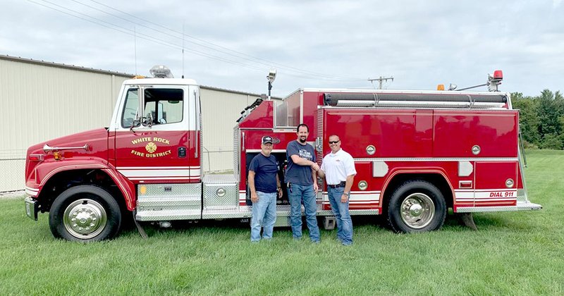 Photo submitted White Rock Fire Chief Joe Lahr (left) and firefighter Fred Parker are congratulated by a Fire Master Fire Equipment staff member upon the department's recent acquisition. The White Rock Fire Department purchased a 2002 diesel model last week to help provide better service for the community. The fire truck, acquired through Fire Master Fire Equipment Inc. in Springfield, will improve the department's fleet. This engine, along with two other diesel fire trucks, will help the department run more efficiently. An older fourth fire truck is a 1977 model, which is not diesel powered.