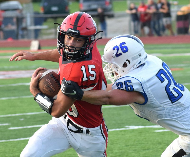 RICK PECK/SPECIAL TO MCDONALD COUNTY PRESS McDonald County running back Jack Teague breaks a tackle by Marshfield's Brett Orso during the Mustangs' season opening 31-14 loss on Aug. 31 at MCHS.