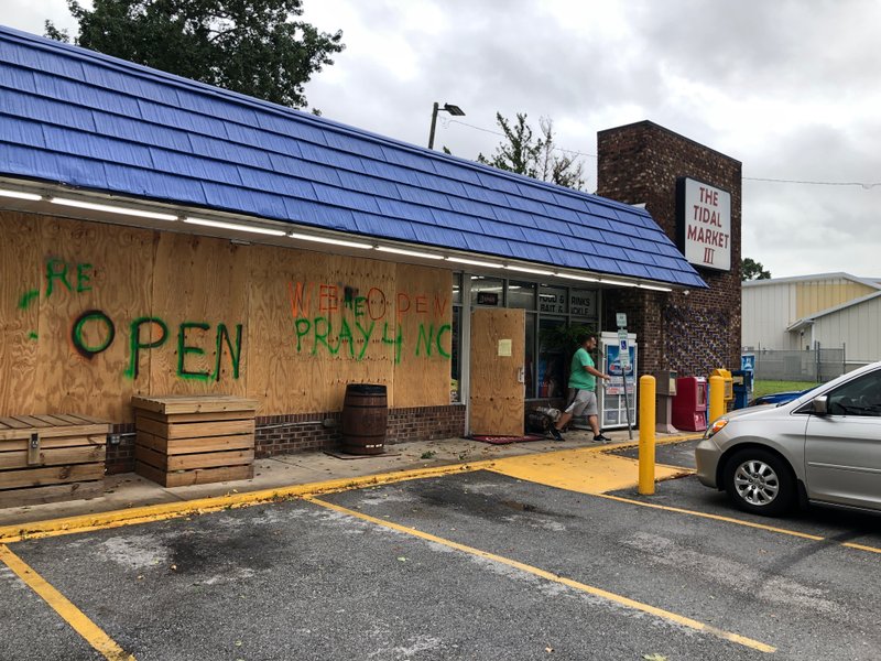 A customer walks out of The Tidal Market III convenience store in Wilmington, N.C, on Thursday, Sept. 5, 2019. Hurricane Dorian was expected to brush just off the coast of the area (AP Photo/Jeffrey Collins)

