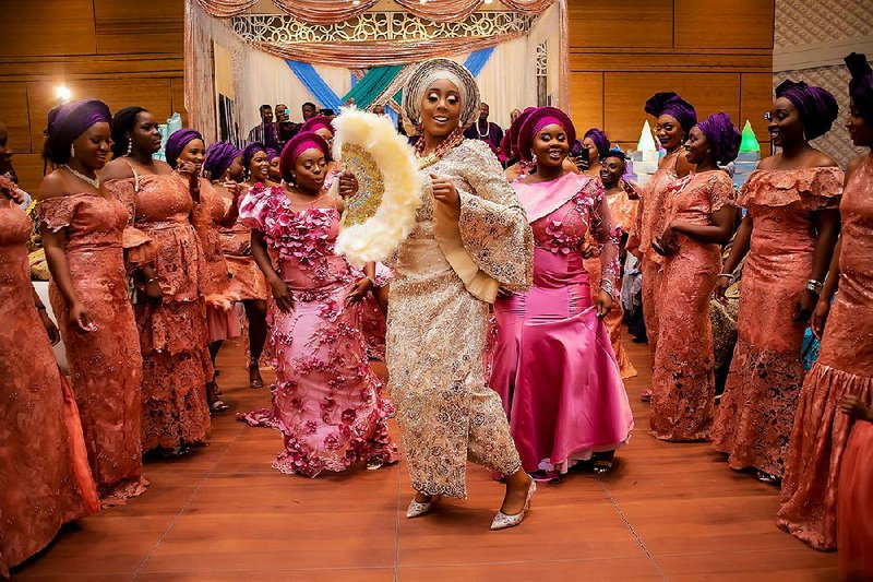 Bride Dola Olutoye dances in to her reception to meet her groom, Yinka Olutoye, during their May 25 wedding in Houston. The color and flair of traditional Nigerian wedding ceremonies give brides and grooms a way to express a vibrant cultural heritage. 