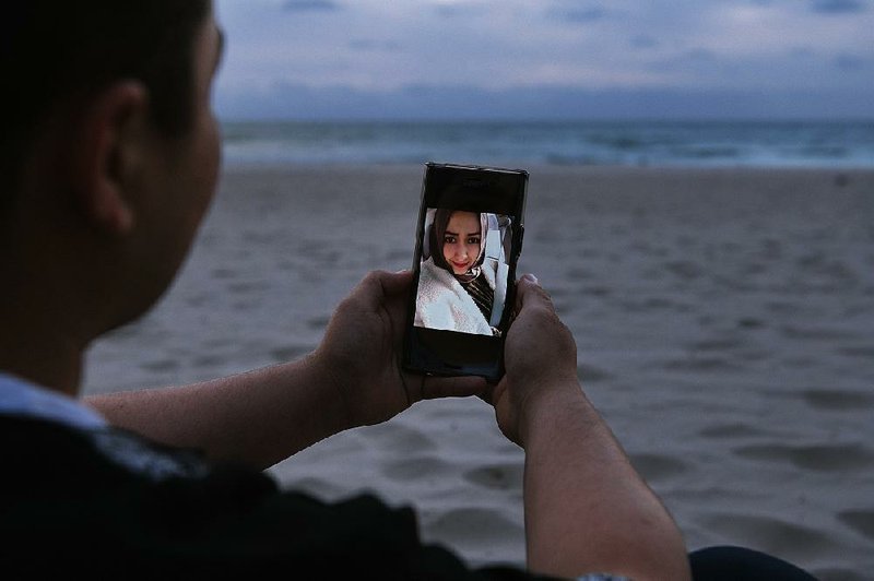 Almas Nizamidin is pictured with his wife, his high school sweetheart, at Glenelg Beach outside Adelaide, Australia, in January. His wife, Buzainafu Abudourexiti, was sentenced to seven years in prison in Xinjiang in 2017 for what Nizamidin calls trumped-up offenses.