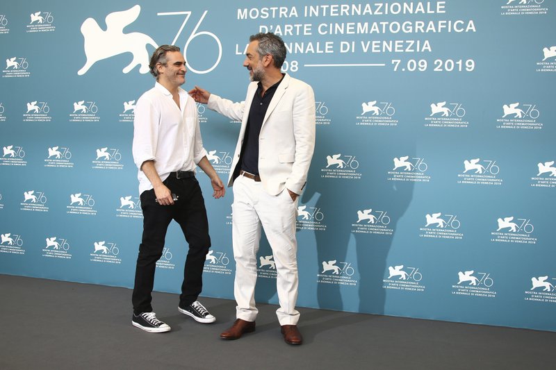 Actor Joaquin Phoenix, left, greets director Todd Phillips at the photo call for the film 'Joker' at the 76th edition of the Venice Film Festival in Venice, Italy, Saturday, Aug. 31, 2019. (Photo by Joel C Ryan/Invision/AP) story.lead_photo.caption