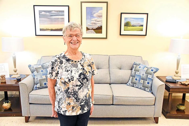 Maumelle artist Mary Ann Stafford has 10 pieces of her work on exhibit in the lobby of Saint Peter’s Episcopal Church in Conway. Paintings shown in the background are, from left, In the Distance, Heading Home and Rural Fields.