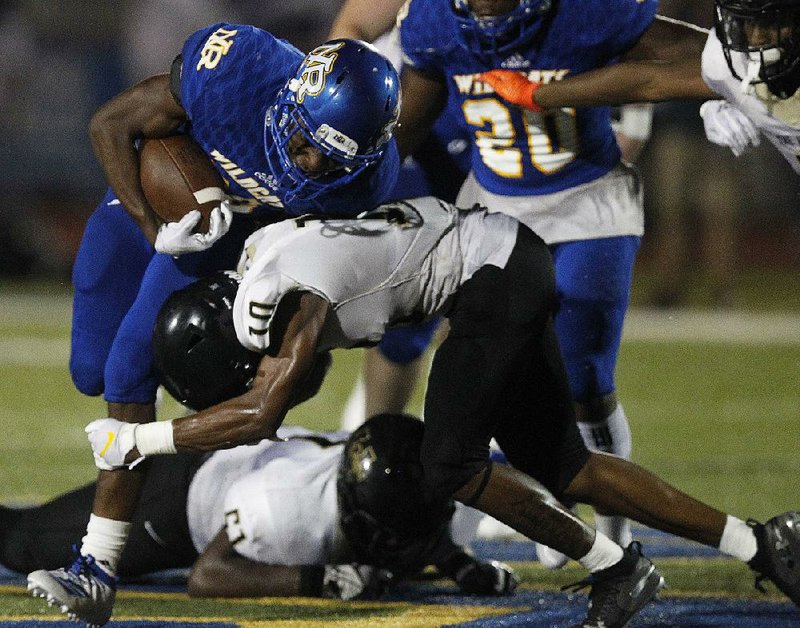 North Little Rock running back Aaron Sims (left) gets hit by a Memphis Whitehaven defender during the fourth quarter of North Little Rock’s 23-0 loss Friday at North Little Rock.