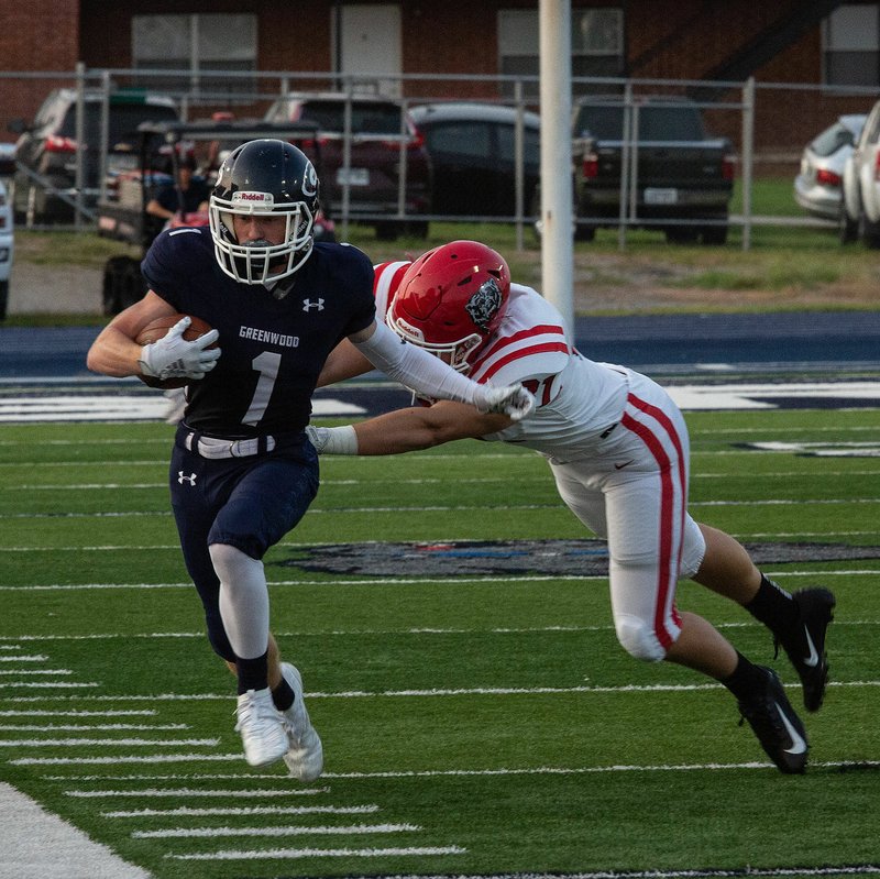 Greenwood’s Caden Brown (1) is forced out of bounds by Fort Smith Northside’s Stenson Van Matre on Friday during the first quarter of the Bulldogs’ 38-10 victory over the Grizzlies in Greenwood.