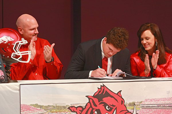 Pulaski Academy's tight end Hunter Henry sign a letter of intent to play football at Arkansas during a ceremony at the school Wednesday, Feb. 6, 2013, in Little Rock. At left is his father Mark Henry and right is his mother Jenny Henry.