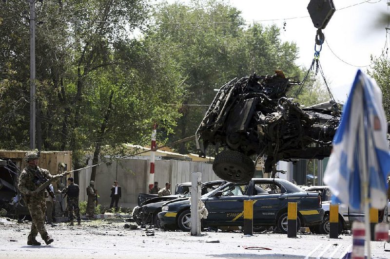 Afghan soldiers clear a vehicle damaged in a car-bomb attack Thursday in Kabul that killed a U.S. service member and a NATO service member. President Donald Trump mentioned the attack in a tweet Saturday announcing the cancellation of secret talks with Taliban leaders and Afghan President Ashraf Ghani at Camp David. 