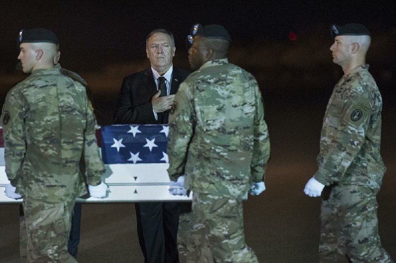 A transfer case containing the remains of Sgt. 1st Class Elis Barreto Ortiz, who was killed last week in Afghanistan, is carried past Secretary of State Mike Pompeo on Saturday night at Dover Air Force Base in Delaware. 