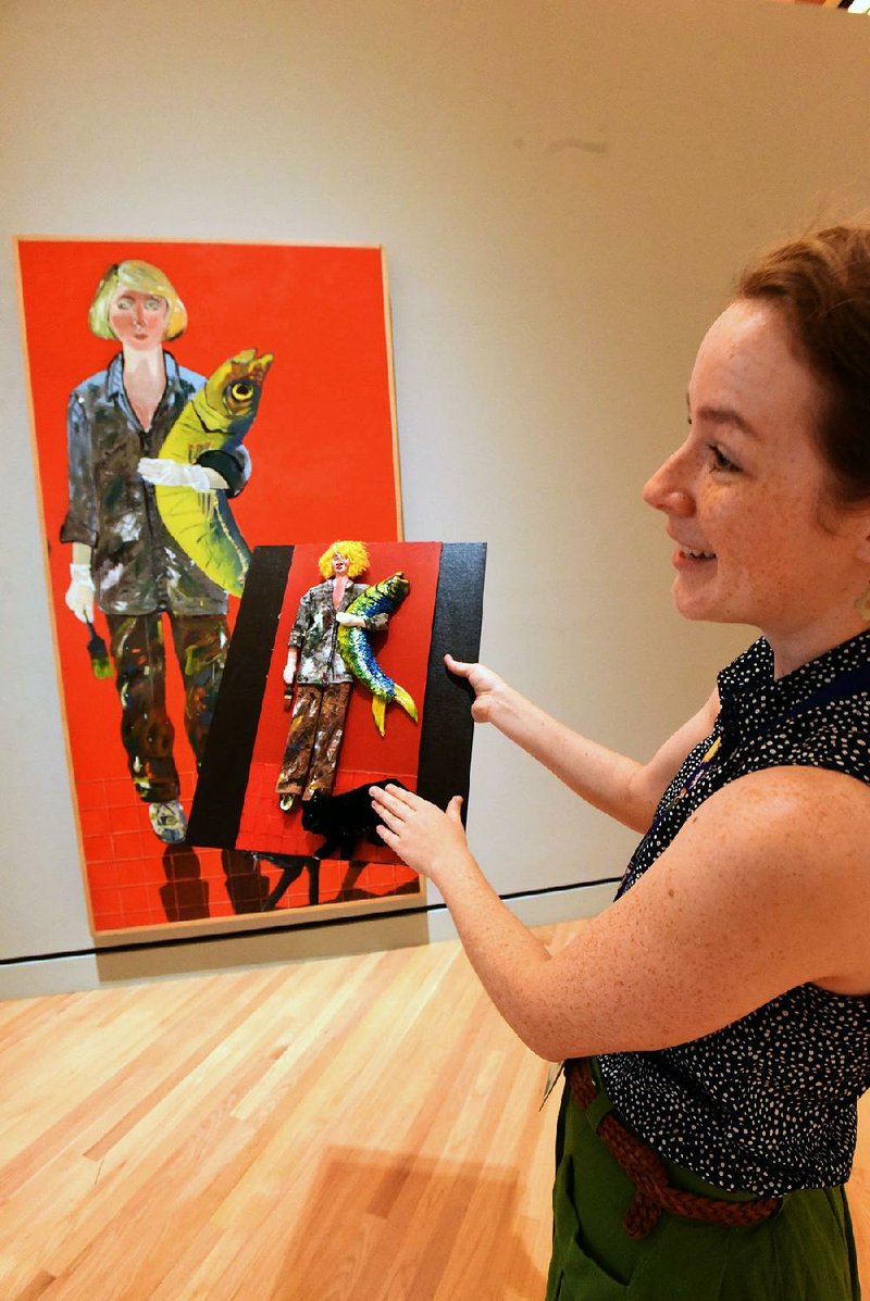 Kim Crowell with the Crystal Bridges Museum of American Art staff holds a touchable version of the painting Self-Portrait with Fish and Cat by Joan Brown, one of the items the museum is using to aid vision-impaired guests. 