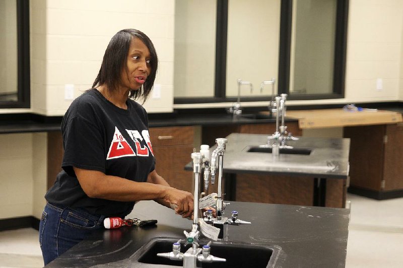 Cassandra Hillery, a 1986 graduate of Central High School in what is now Helena-West Helena, looks over the fixtures in the new school’s chemistry lab. More photos from the new high school are available at arkansasonline.com/99school/. 