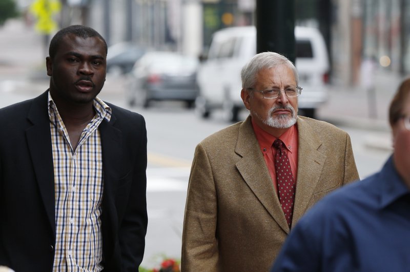 FILE - In this July 9, 2015, file photo, Michael Geilenfeld, right, arrives at U.S. Bankruptcy Court, Thursday, July 9, 2015, in Portland, Maine. An attorney says a defamation lawsuit against a Maine activist who accused an orphanage founder in Haiti of being a serial pedophile has been settled. Paul Kendrick&#x2019;s attorney told The Associated Press that the defendant&#x2019;s insurance companies agreed to pay $3 million to Hearts With Haiti but nothing to orphanage founder Michael Geilenfeld. The attorney says Hearts With Haiti and Geilenfeld dropped their defamation claims. (AP Photo/Robert F. Bukaty, File)