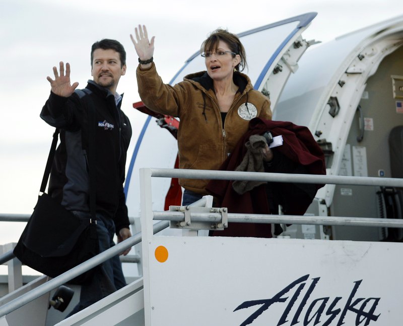 FILE - In this Nov. 4, 2008 file photo, Republican vice presidential candidate Alaska Gov. Sarah Palin and her husband Todd wave as they leave the Ted Stevens Anchorage International Airport in Anchorage, Alaska bound for Wasilla to vote in the presidential election. Court documents suggest the husband of former Alaska governor and 2008 vice-presidential nominee Sarah Palin is seeking a divorce. The court papers were filed by a plaintiff identified as T.M.P. against S.L.P. Friday, Sept. 6, 2019. Todd Palin's middle name is Mitchell and Sarah Palin's middle name is Louise. The documents also note the couple married Aug. 29, 1988, the same wedding date as the Palins. (AP Photo/Ted S. Warren, File)