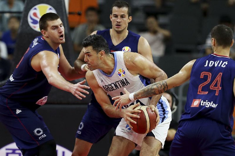 Argentina’s Luis Scola (middle) tries to maneuver around three Serbian defenders Tuesday during Argentina’s 97-87 victory at the FIBA World Cup in Dongguan, China. Scola finished with 20 points. 