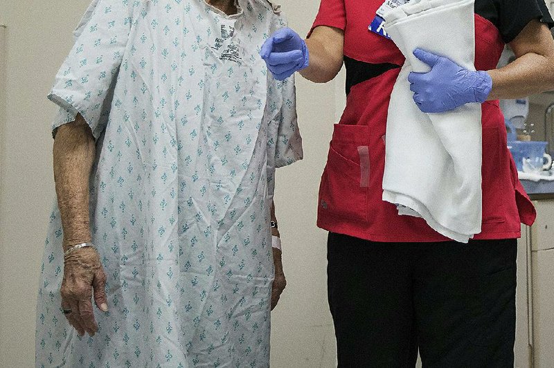 A nurse prepares a patient for a CT scan in Mountain Home in 2017. The number of people in Arkansas without health insurance rose by about 12,000 from 2017-18, census figures show. The increase follows a national trend. 