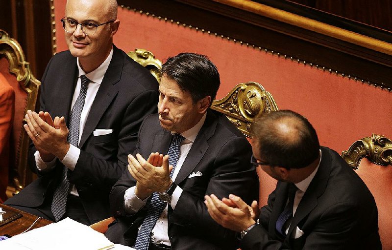 Prime Minister Giuseppe Conte (center) applauds Tuesday after winning a second confidence vote at the Senate in Rome. 