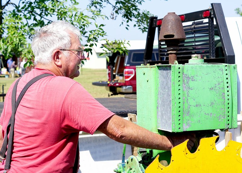 Westside Eagle Observer/RANDY MOLL Ed Malcom, of Pineville, Mo., gets read to start a 1924 LeRoi engine at the Tired Iron of the Ozarks showgrounds on Friday, Sept. 6, 2019. He said the 2-cylindar, hopper-cooled engines were so well made they never wear out and need almost no maintenance. He said he has an engine that ran 69 years in a rice field, logging 290,000 hours, and it still runs fine.