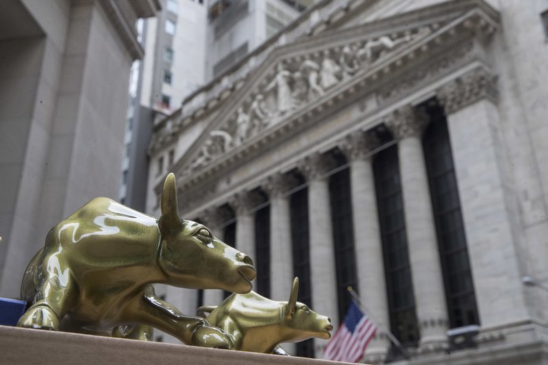 In this April 24, 2018, file photo replicas of Arturo Di Modica's "Charging Bull" are for sale on a street vendor's table outside the New York Stock Exchange. (AP Photo/Mary Altaffer, File)