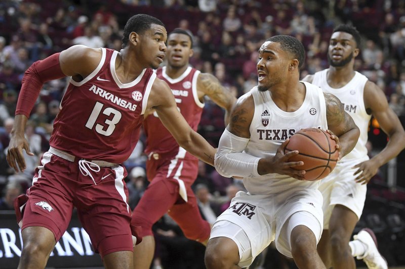Texas A&M's TJ Starks (2) faces Arkansas' Mason Jones (13) near the basket in the first half of an NCAA college basketball game Saturday, Jan. 5, 2019, in College Station, Texas. (Laura McKenzie/College Station Eagle via AP)