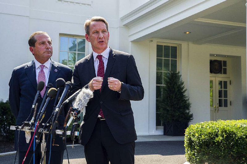 Health and Human Services Secretary Alex Azar (left), and Ned Sharpless, acting director of the federal Food and Drug Administration, discuss the vaping policy Wednesday outside the White House. 