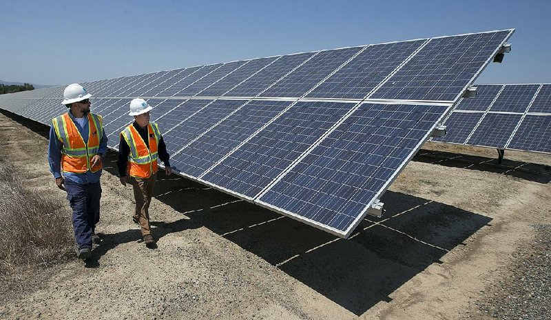 Solar energy tech Joshua Valdez (left) and senior plant manager Tim Wisdom check out solar panels in 2017 at a Pacific Gas and Electric solar plant in Dixon, Calif. U.S. energy prices dropped 2.5% in August, the Labor Department said Wednesday. 