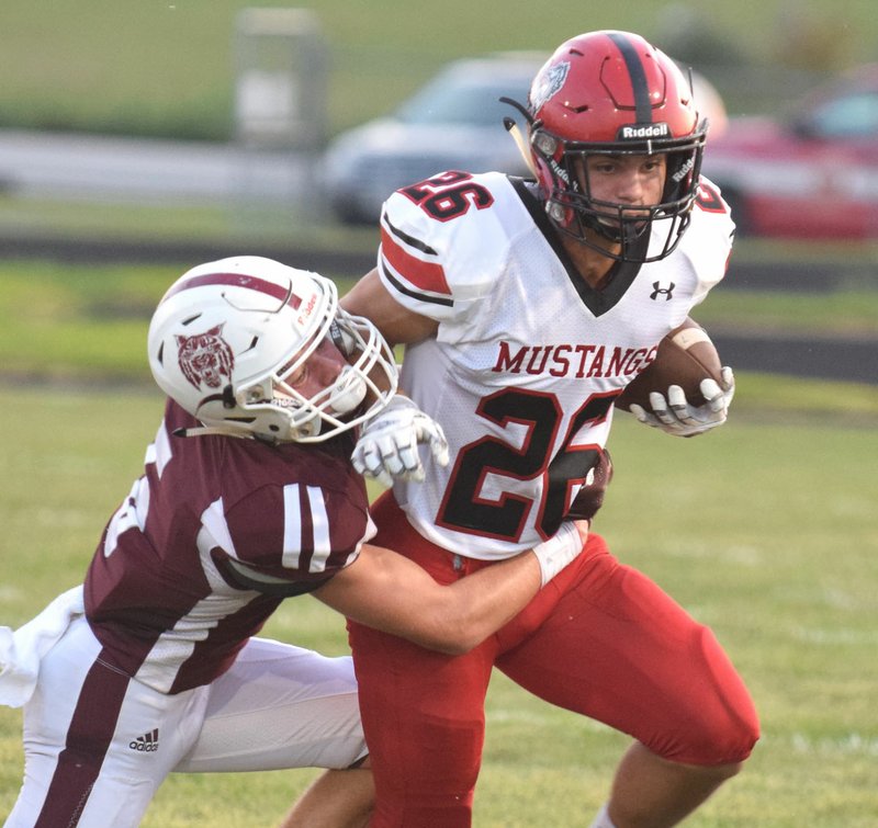 RICK PECK/SPECIAL TO MCDONALD COUNTY PRESS McDonald County wide receiver Corbin Jones gets tackled by Logan-Rogersville's McKinley Feith for a short gain during the Mustangs' 53-20 loss on Sept. 6 at Logan-Rogersville High School.