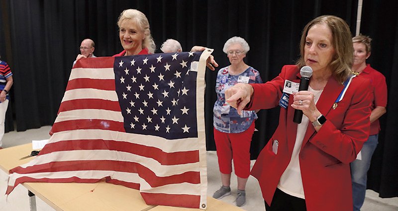 John Percifull Chapter of the Daughters of the American Revolution members Robin Williams, left, and Cindy Smith take part in a flag retirement ceremony during a Patriot Day event at the Lakeside Middle School Wednesday. - Photo by Richard Rasmussen of The Sentinel-Record