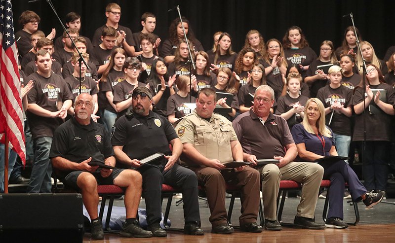 From left, Hot Springs firefighter Dean Brooks, Hot Springs police Sgt. Allen Constant, Garland County sheriff's Deputy Richard Huffman, school security representative Jeff Britt and school nurse Amy Graves sit on stage during an awards ceremony at a 9/11 remembrance ceremony at the school Wednesday. - Photo by Richard Rasmussen of The Sentinel-Record