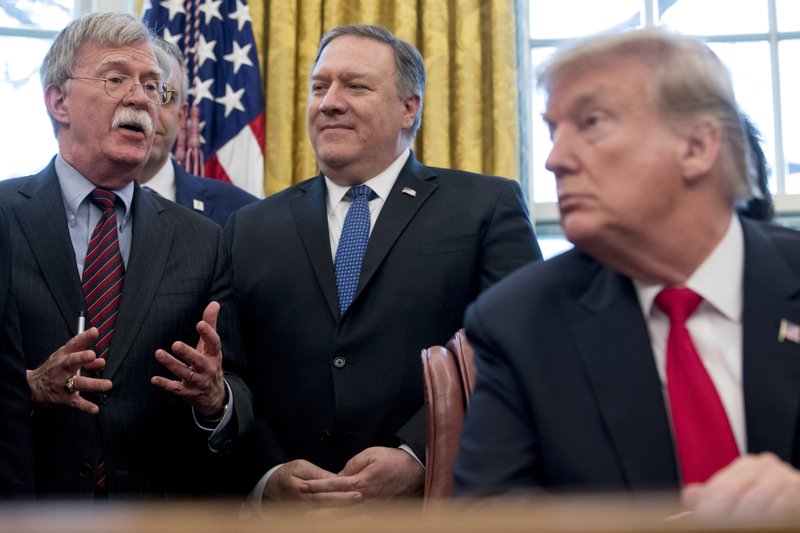 FILE - In this Feb. 7, 2019 file photo, from left, National Security Adviser John Bolton, accompanied by Secretary of State Mike Pompeo, and President Donald Trump, speaks before Trump signs a National Security Presidential Memorandum to launch the &quot;Women's Global Development and Prosperity&quot; Initiative in the Oval Office of the White House in Washington. Trump has fired national security adviser John Bolton. Trump tweeted Tuesday that he told Bolton Monday night that his services were no longer needed at the White House. (AP Photo/Andrew Harnik)