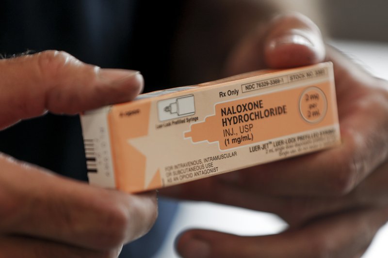 Akron fire medic Paul Drouhard shows a box containing Naloxone Hydrochloride, that is carried in all their departments emergency response vehicles, Wednesday, Sept. 11, 2019, in Akron, Ohio. The drug commonly called Narcan is used primarily to treat narcotic overdoses. Attorneys representing some 2,000 local governments said Wednesday they have agreed to a tentative settlement with OxyContin maker Purdue Pharma over the toll of the nation's opioid crisis. (AP Photo/Keith Srakocic)