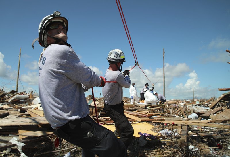 Members of the fire rescue team Task Force 8, from Gainesville, Florida, help remove a body one week after Hurricane Dorian hit The Mudd neighborhood in the Marsh Harbor area of Abaco Island, Bahamas, Monday, Sept. 9, 2019. Dorian, the most powerful hurricane in the northwestern Bahamas' recorded history, has killed at least 44 people in Bahamas as of Sunday, Sept. 8, according to the government. (AP Photo/Gonzalo Gaudenzi)