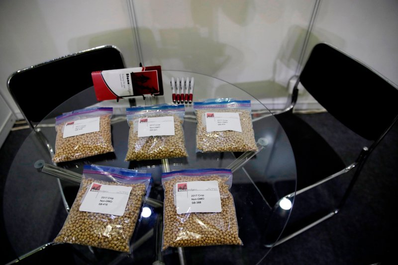 In this April 12, 2018, file photo, packets of raw soybeans are placed on a table at a U.S. soybean company's booth at the international soybean exhibition in Shanghai, China. China has announced some U.S. industrial chemicals will be exempt from tariff hikes imposed in a trade war with Washington but maintained penalties on soybeans, pork and other farm goods. 