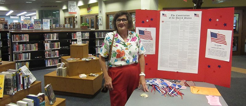 Submitted photo CONSTITUTION WEEK DISPLAY: In recognition of Constitution Week, Sept. 17-23, the Hot Springs of Arkansas Chapter of DAR placed a factual display at the Garland County Library with American flags and patriotic wands free to the public. With the display is Karen Wacaster, Hot Springs Chapter of DAR.