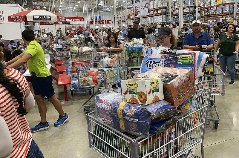 Food costs for shoppers like these at a Florida Costco store recently were unchanged for a third straight month, according to inflation reports for August. Clothing costs edged up for the month.