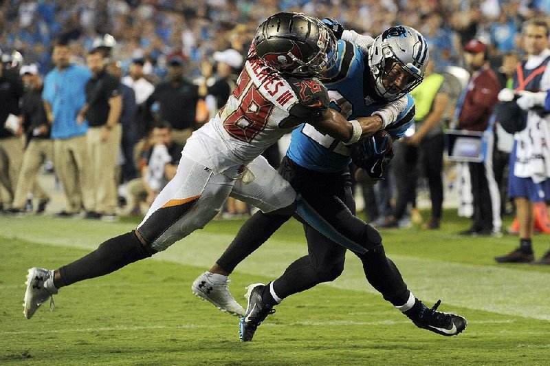 Tampa Bay Buccaneers cornerback Vernon Hargreaves III (left)  stops Carolina Panthers running back Christian McCaffrey short  of the goal line on fourth down in the closing minutes to secure the Buccaneers’ victory Thursday night in Charlotte, N.C. 