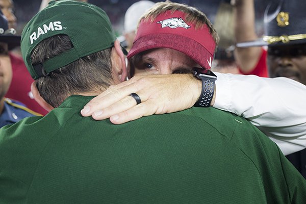 Arkansas coach Chad Morris (facing) shakes hands with Colorado State coach Mike Bobo following a game Saturday, Sept. 8, 2018, in Fort Collins, Colo.