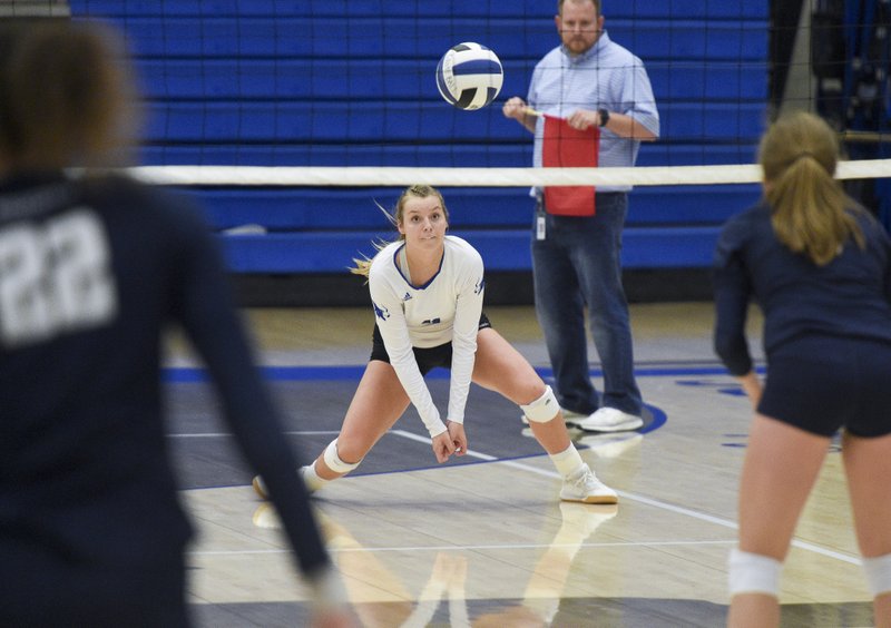 Rogers High School outside hitter Gracie Carr (11) digs during a volleyball game, Thursday, September 12 at Rogers High School King Arena in Rogers.