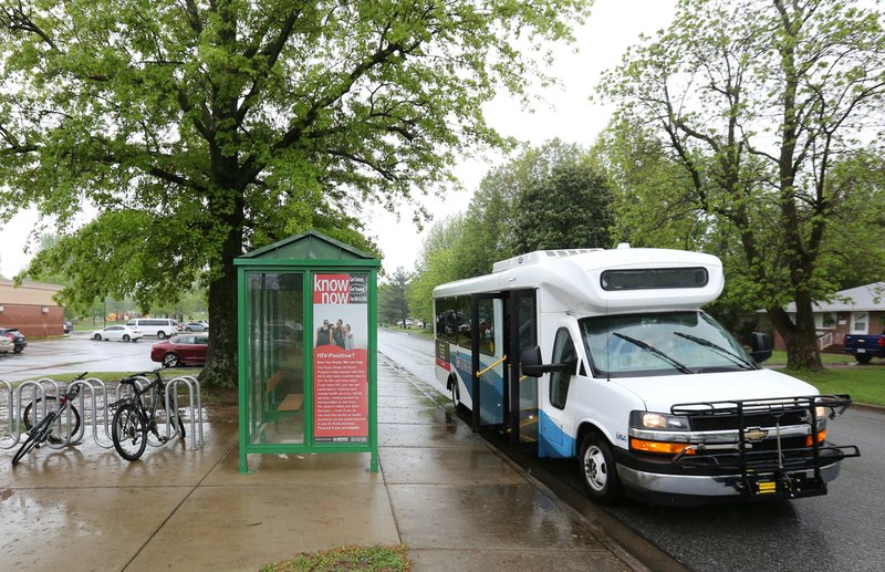 An Ozark Regional Transit bus pulls away Thursday, April 25, 2019, from the stop at the Springdale Public Library.