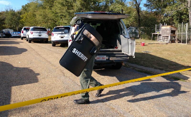 An unidentified officer dressed in tactical gear joins in the search for a stabbing suspect on Trace Court Saturday. - Photo by Tanner Newton of The Sentinel-Record