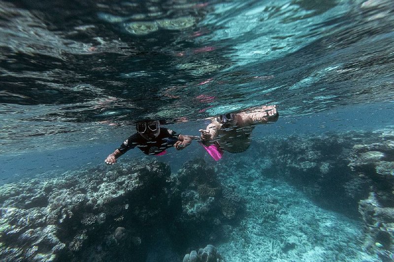Murrumu of Walubara (right), once known as political reporter Jeremy Geia, snorkels along the Great Barrier Reef with his son, Thoyo, on Thoyo’s 11th birthday Aug. 8. Walubara pokes at assumptions of Australian sovereignty and land ownership in the region where he lives: “It’s just a truth that’s unfamiliar to you,” he tells people who don’t follow his line of thinking. 