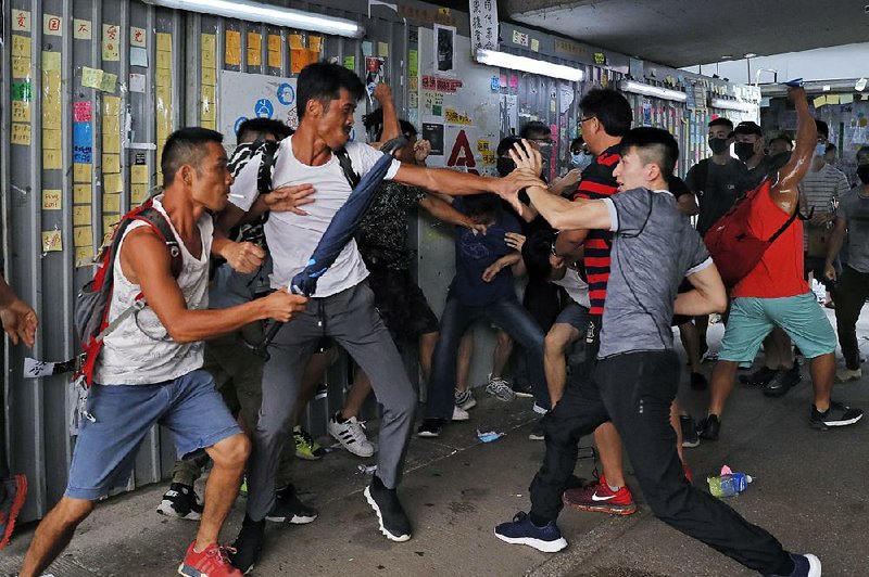 Pro-police supporters clash Saturday with an anti-government protester (right) outside the Amoy Plaza in the Kowloon Bay district of Hong Kong. 