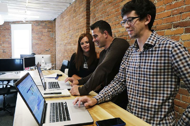 Shane Griffiths (right) and Trenton Erker (center) co-owners of the Seattle digital marketing company Clarity Online, work with one of their clients, spa owner Susan Leeming. 
